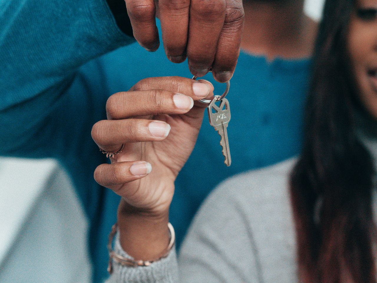 Services A couple holding a key, symbolizing a new home ownership or rental.